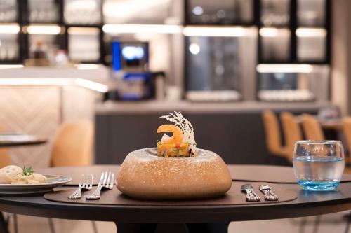 a table with a plate of food on top of it at NH Ciudad de Santiago in Santiago