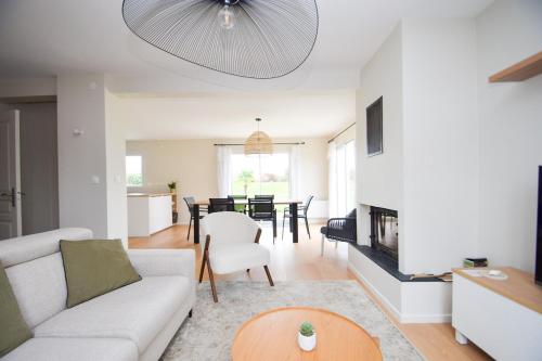 un salon avec un canapé et une table dans l'établissement Maison rénovée 6 personnes proche des plages, à Ploubalay