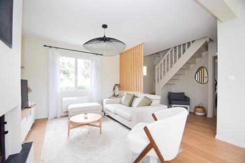 - un salon blanc avec un canapé blanc et des escaliers dans l'établissement Maison rénovée 6 personnes proche des plages, à Ploubalay