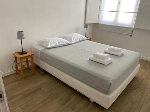 a bedroom with a large bed with towels on it at Alfazema Alojamento Local in Angra do Heroísmo