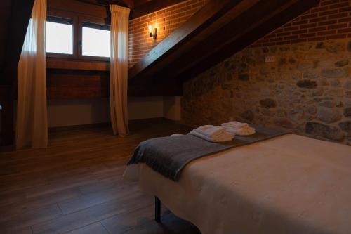 a bedroom with a bed in a stone wall at La casita del abuelo in Galizano