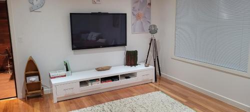 a living room with a flat screen tv on a wall at Beach front unit in Capel Sound in Capel Sound