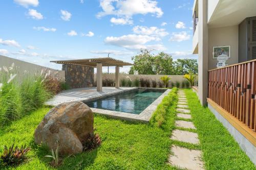a backyard with a swimming pool and a gazebo at Indian Summer by IHR in Flic-en-Flac