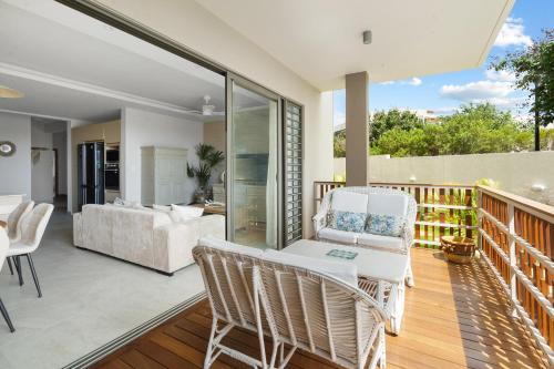 a patio with white chairs and a living room at Indian Summer by IHR in Flic-en-Flac
