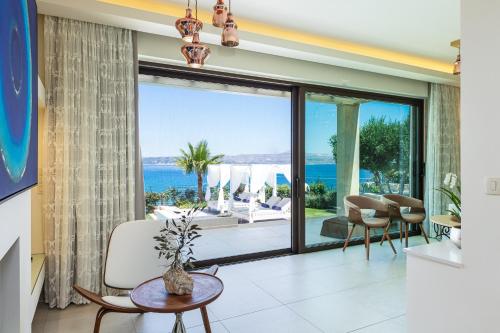 a living room with a large glass door with a view of the ocean at Miraida Exclusive Residence in Almirida