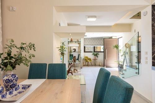 a dining room with a table and blue chairs at Miraida Exclusive Residence in Almirida