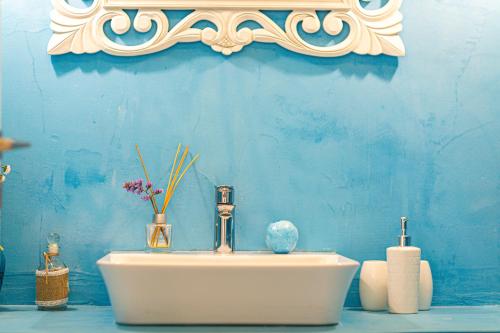 a bathroom with a sink with a blue wall at Miraida Exclusive Residence in Almirida