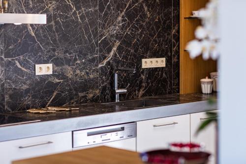 a kitchen with a marble counter top and a sink at Miraida Exclusive Residence in Almirida
