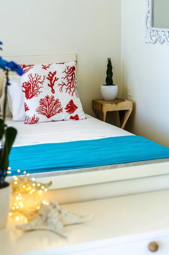 a bed with a red and white pillow on it at Miraida Exclusive Residence in Almirida