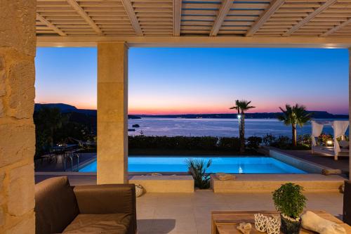 a villa with a view of the ocean at dusk at Miraida Exclusive Residence in Almirida