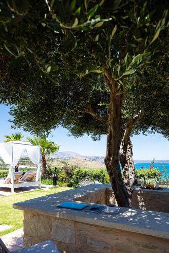 a table under a tree next to a tree at Miraida Exclusive Residence in Almirida