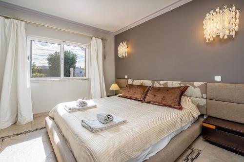 a bedroom with a large bed with towels on it at Villa Felicity in Porches
