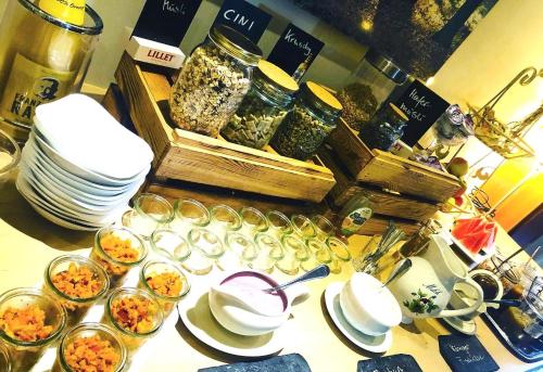 een tafel met borden en glazen en schalen van voedsel bij Pension & Restaurant Nordstern in Cottbus