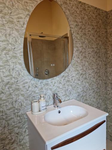 a bathroom with a sink and a mirror on the wall at La Corte dell'Angelo - Riccardo Room in Orio al Serio