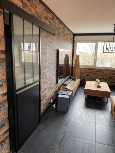 - un salon avec un mur en briques et une porte dans l'établissement Au petit bonheur imprévu, à Douai