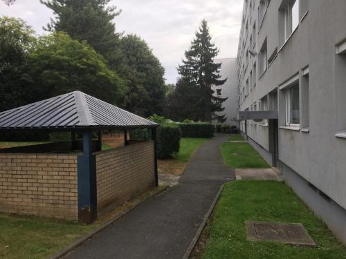 a building with a gazebo next to a street at Au petit bonheur imprévu in Douai