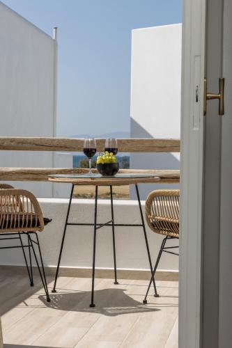 a table with two glasses of wine and two chairs at Marine Dream in Plaka