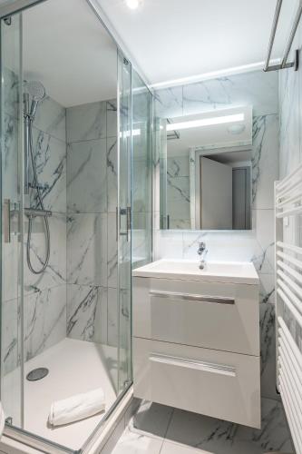 une salle de bain avec une douche en verre et un lavabo dans l'établissement Les Tonnelles, à Sévrier