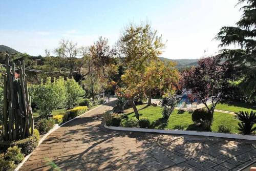 a garden with trees and a brick walk way at Villa Vallereale giardino e piscina uso esclusivo in Itri