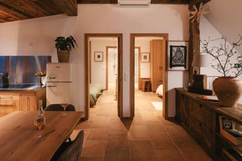 a kitchen with a wooden table and a refrigerator at Guesthouse Novak -Modern Barn Loft in Dvor