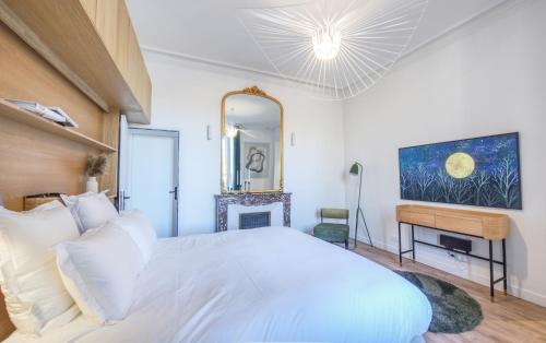 a bedroom with a white bed and a mirror at Villa Victor Hugo by Odomo in Avignon