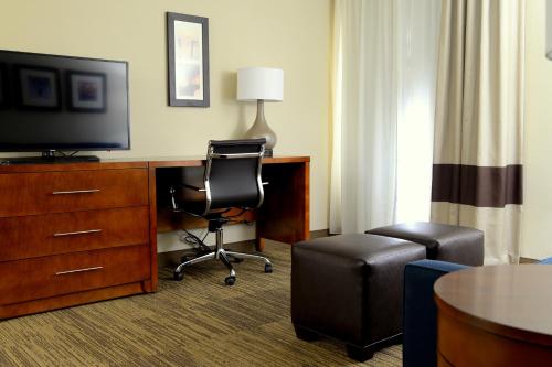 a hotel room with a desk with a television and a chair at Comfort Inn University Durham - Chapel Hill in Durham