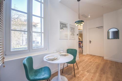 a dining room with a white table and green chairs at Villa Victor Hugo by Odomo in Avignon