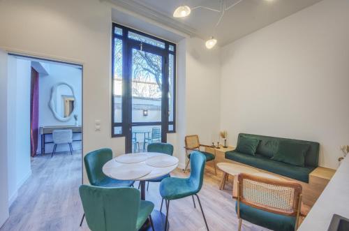 a living room with a table and chairs and a couch at Villa Victor Hugo by Odomo in Avignon