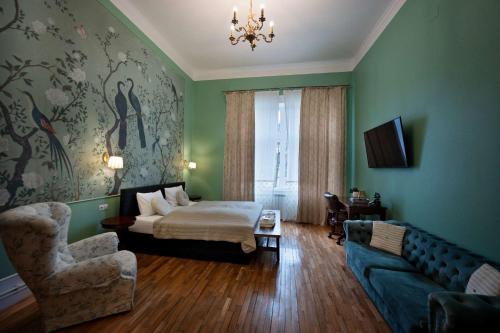 a bedroom with a bed and a couch and a chair at Victoria Apartment 1901-Apartament ultracentral Oradea ,lângă Piața Unirii in Oradea