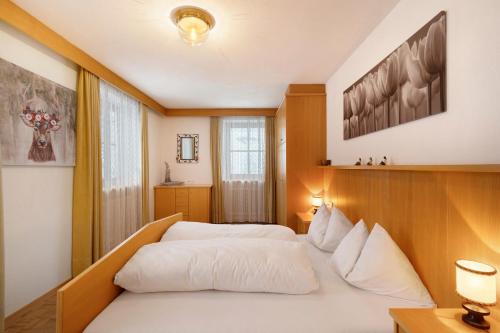 a bedroom with a white bed and a window at Untersinnerhof Gsies in Valle Di Casies