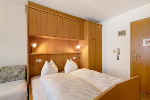 a bedroom with a large bed with white sheets at Untersinnerhof Gsies in Valle Di Casies