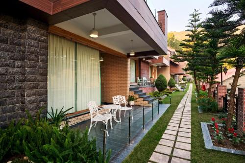 a patio with chairs and tables on a house at Deventure Shimla Hills in Kandāghāt