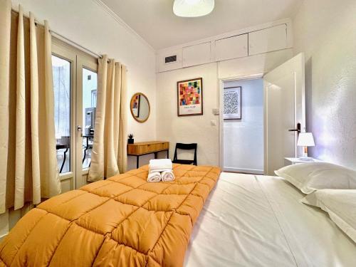 a bedroom with a large bed with an orange blanket at ApartHotel Riviera - Maison de la Poissonnerie - Vieille Ville - Grand Appartement 3 piece AC - 5min de la Promenade des Anglais in Nice