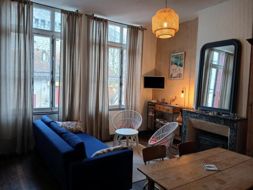 a living room with a blue couch and a table at Agréable maison avec jardin dans le centre historique de Bourdeilles in Bourdeilles