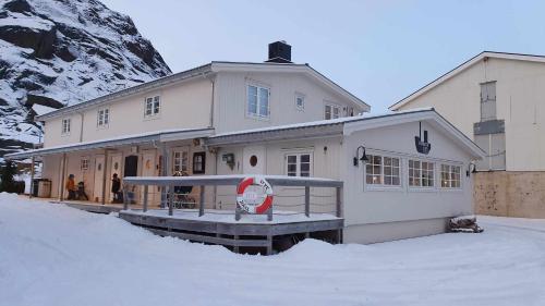 a house in the snow in front of a mountain at Kaikanten Rorbuer in Sennesvik