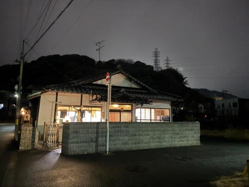 una piccola casa con una bandiera davanti di Wholeearth Ryokan Hiroshima a Hiroshima