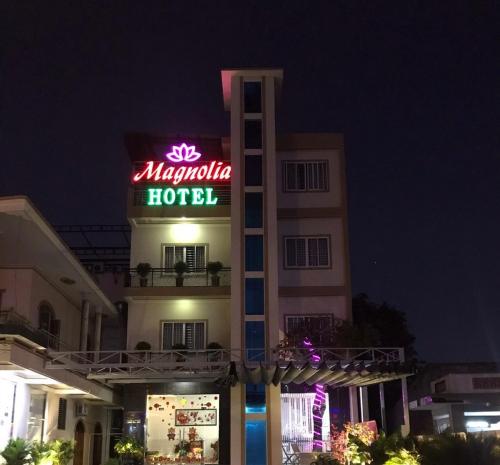 a hotel with a neon sign in front of it at Magnolia Hotel Cam Ranh in Cam Ranh