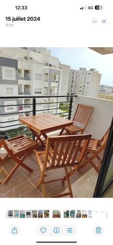 a wooden table and chairs on a balcony at Lynda in Nabeul