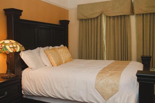 a bedroom with a bed with white sheets and pillows at Gilmore Hotel, Trademark Collection by Wyndham in Ketchikan