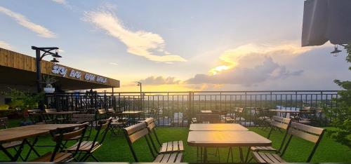 a patio with tables and chairs with a view of the ocean at Magnolia Hotel Cam Ranh in Cam Ranh