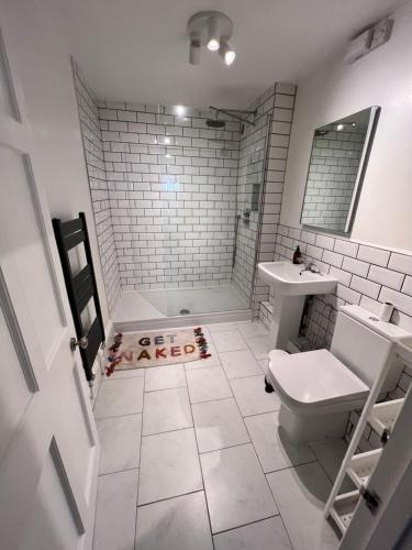 a white bathroom with a toilet and a sink at Beautiful Modern Central Flat in Cheltenham