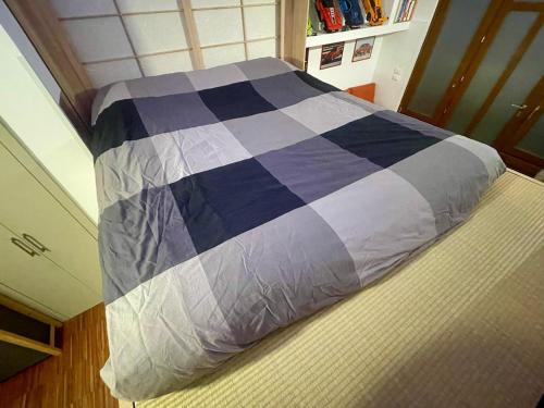 a bed in a bedroom with a blue and purple comforter at Loft - Pioltello in Pioltello