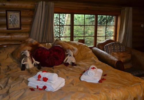 a bed with towels and stuffed animals on it at Traditional Log Cabin next to Harry Potter Studios in Kings Langley