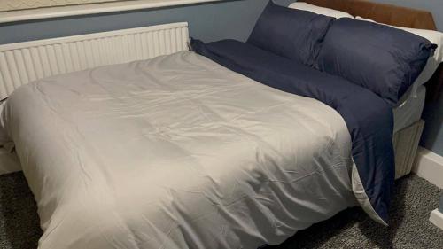 1 cama con sábanas azules y blancas y almohadas azules en HouseSleeps9-Fireplace-Garden-Bbq-Tv, en Mánchester