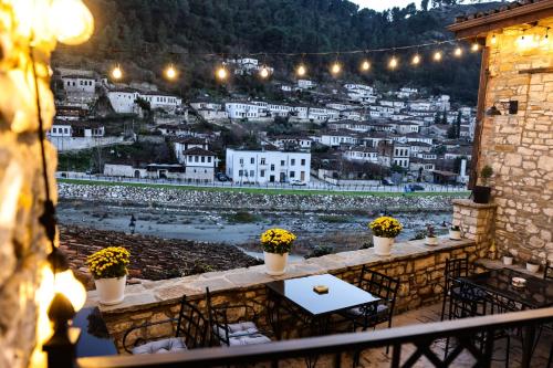 a view of a city from a balcony with tables and flowers at White House Boutique Hotel & Restaurant - since 1999 in Berat