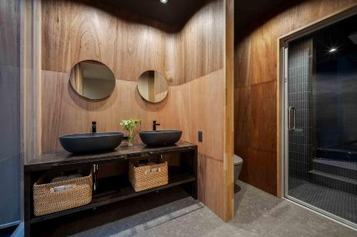 two sinks in a bathroom with two mirrors at Hanasatomachi Machiya House in Takayama
