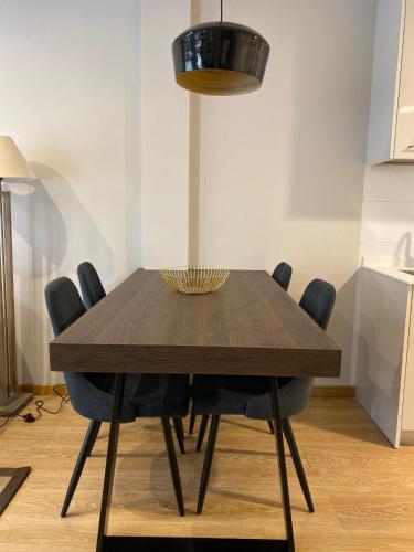 a dining room table with blue chairs and aendant light at Apartamentos Turisticos de Soria Collado 3 in Soria
