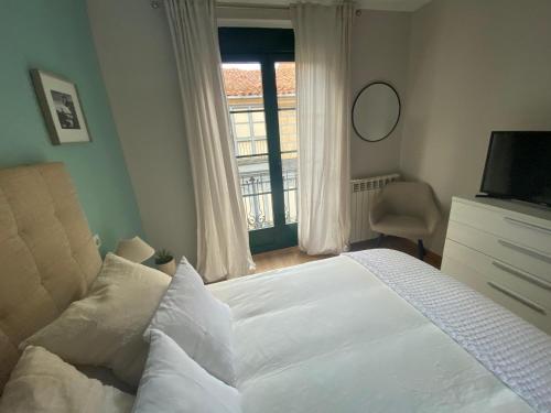 a bedroom with a white bed and a window at Apartamentos Turisticos de Soria Collado 3 in Soria