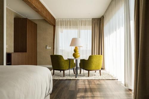 a hotel room with a bed and a table and chairs at Garden Suites - Handwritten Collection in Burgh Haamstede