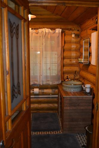 a bathroom with a sink in a log cabin at Traditional Log Cabin next to Harry Potter Studios in Kings Langley